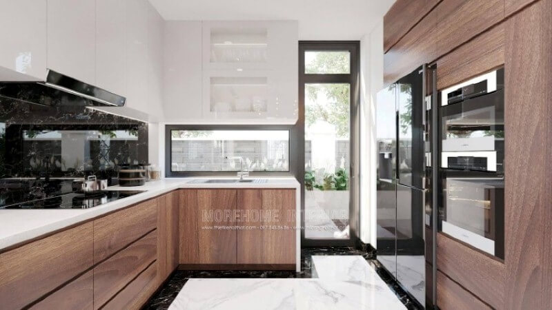 Trong thiết kế không gian phòng bếp biệt thự hiện đại, vật liệu ốp bếp rất được chú trọng bởi điều hiển nhiên xảy ra khi nấu nướng sẽ có nhiều vết bắn dầu mỡ nếu không được lau sạch sẽ gây ra ẩm mốc. Khắc phục điều đó, kính ốp bếp hay đá ốp bếp đều là lựa chọn tối ưu, nhưng nếu có điều kiện đá marble đen chỉ trắng như trong mẫu phòng bếp trong đây sẽ là lựa chọn đáng chú ý. Đá ốp bếp biệt thự