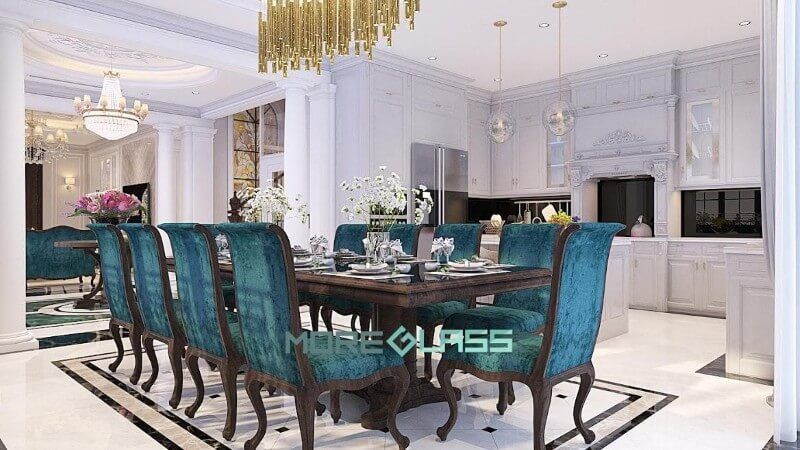 Thiết kế nội thất phòng bếp liền phòng ăn mang phong cách hoàng gia với màu trắng là chủ đạo. Điểm nhấn là bộ kính bếp màu đen huyền bí và bộ bàn ghế ăn màu xanh sang trọng.